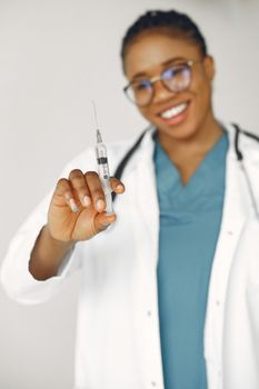 A confident female doctor holding a syringe, ready for vaccination.