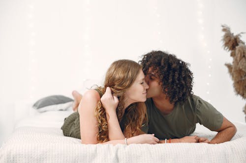 Free A Man with a Curly Hair Kissing a Woman Stock Photo