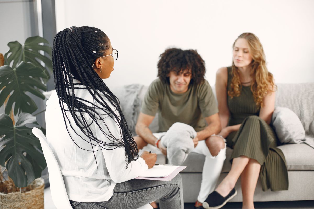 Couple in a counselling office comparing betrayal trauma therapy and couples counselling approaches