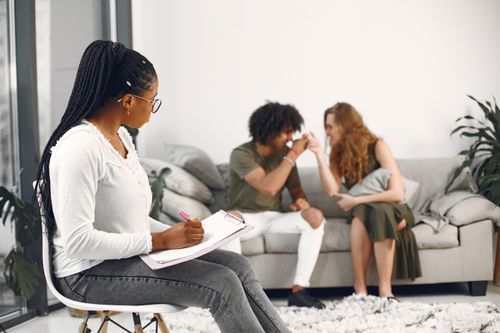 Free A couple receiving relationship counseling from a professional consultant indoors. Stock Photo