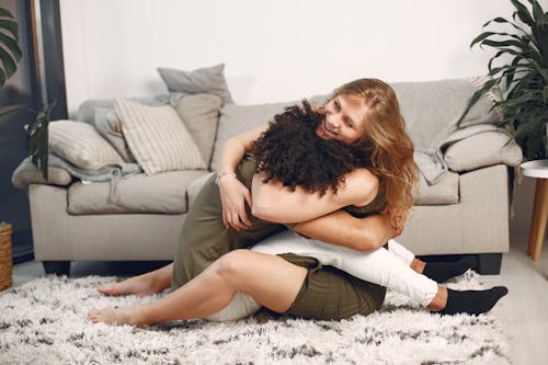 Free Couple Embracing While Sitting on a Carpet Stock Photo