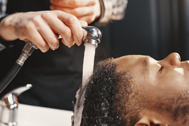 Person Washing A Man's Hair