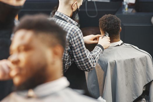 A barber expertly trims a client's hair in a contemporary salon setting.