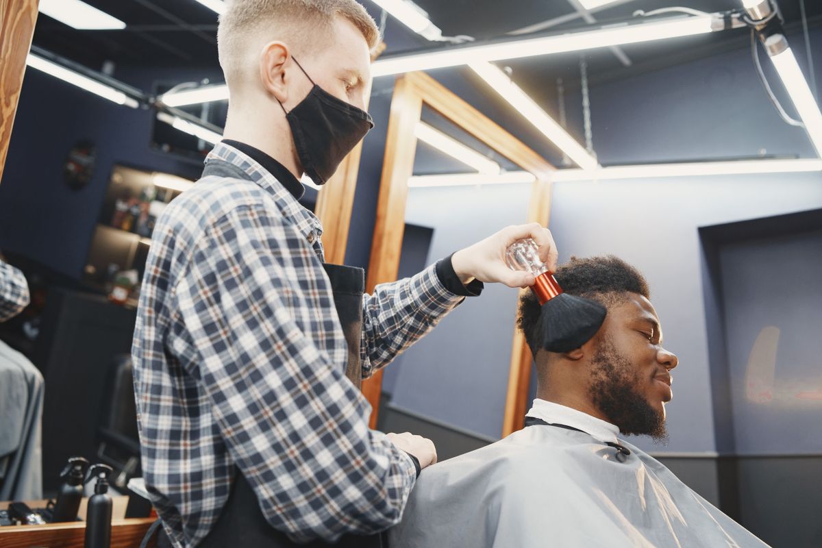 A barber giving a client a haircut in a barbershop