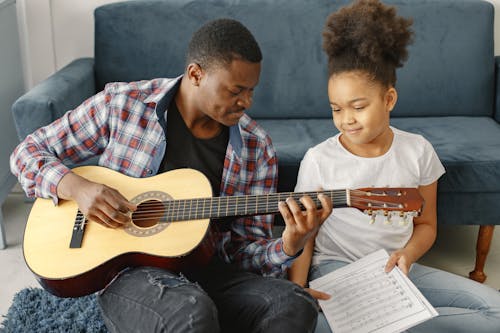 Father and Daughter Playing a Guitar