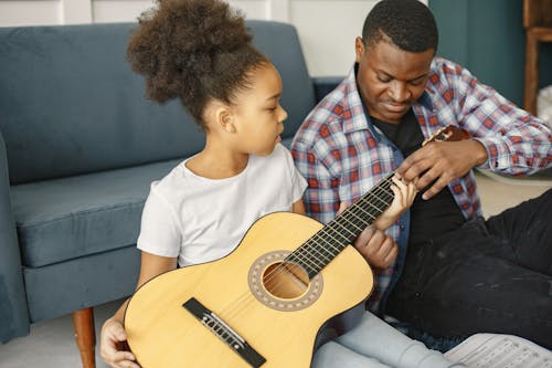 Father Teaching His Daughter to Play the Guitar 