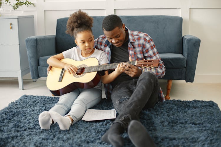 Man Teaching Girl How To Play Guitar