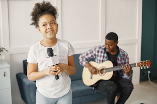 A Young Girl Singing using a Microphone