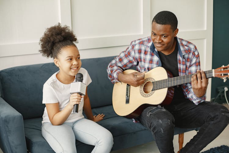 Father Playing The Guitar And Daughter Singing 