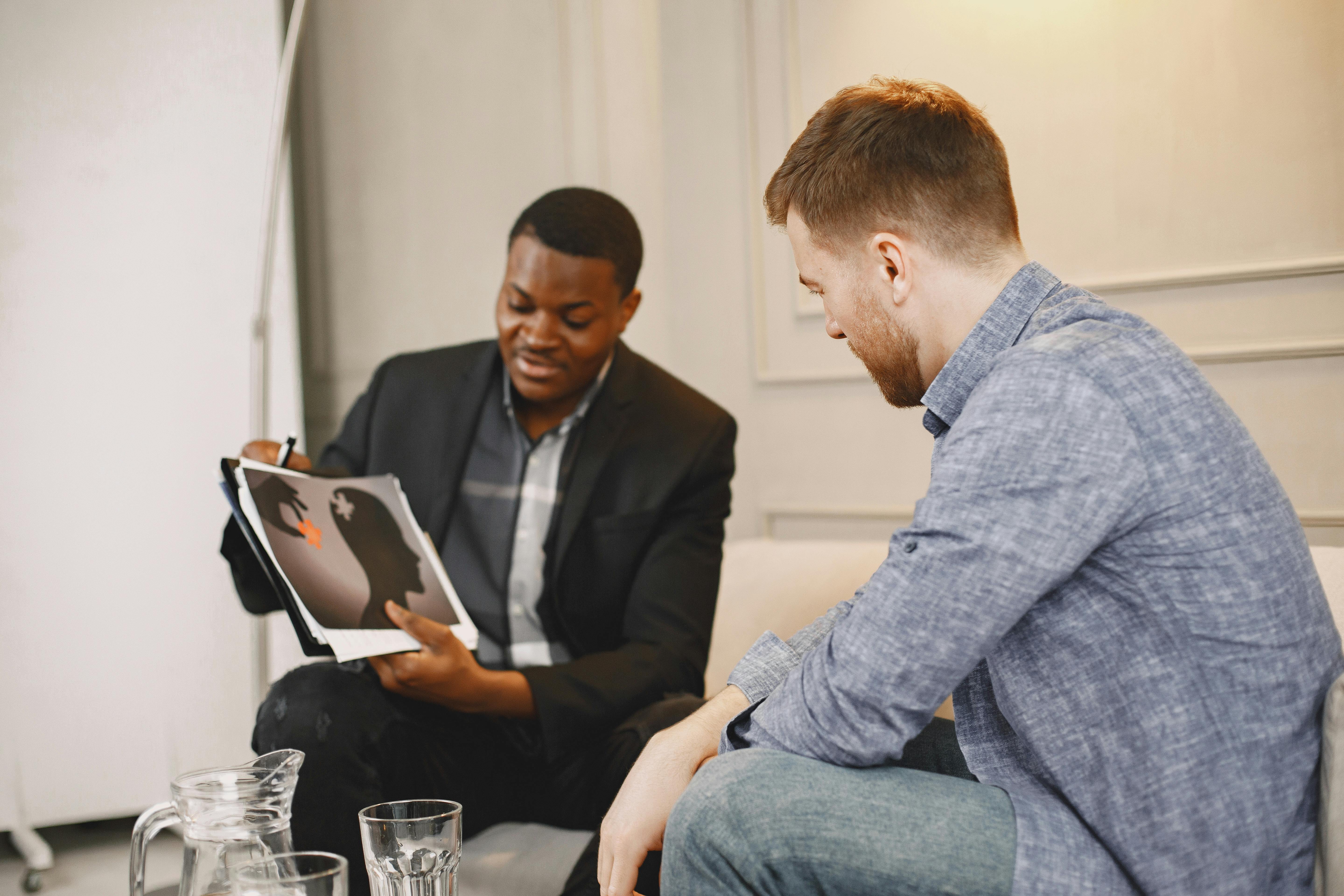 man showing an x ray image of violence to a man in blue long sleeve shirt