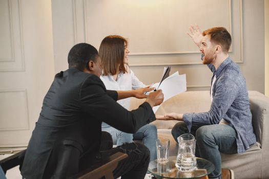 Intense business meeting with diverse group discussing documents.
