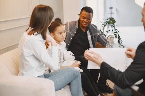 Free Photo of a Girl Looking at a Card with Her Parents Stock Photo