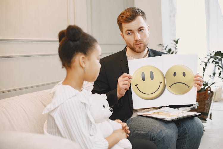 Photograph Of A Therapist Showing Emotions To A Child