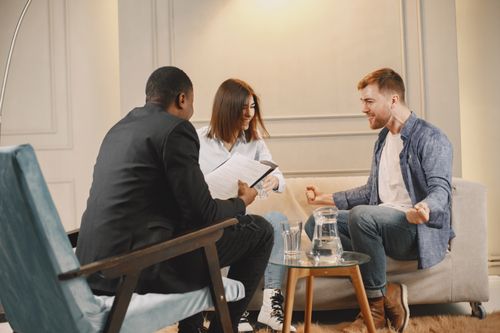 Free Three professionals engaged in a collaborative meeting in a modern office setting. Stock Photo