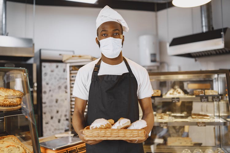 Man Carrying A Brown Tray Filled With Bread