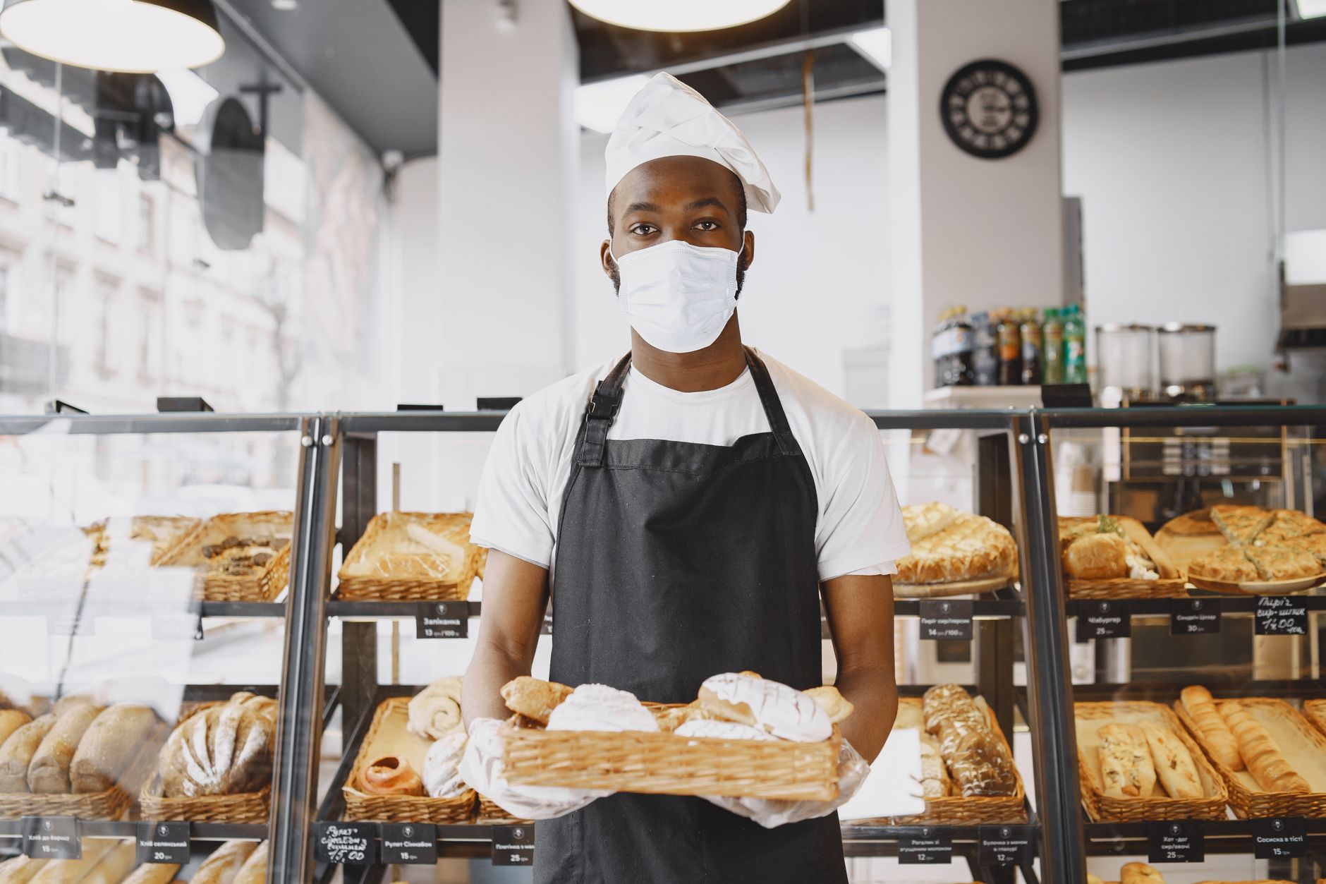 Boulanger présentant un plateau de pains frais pour la vente en click and collect