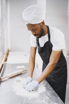 A professional baker working in a commercial kitchen to meet baking career requirements