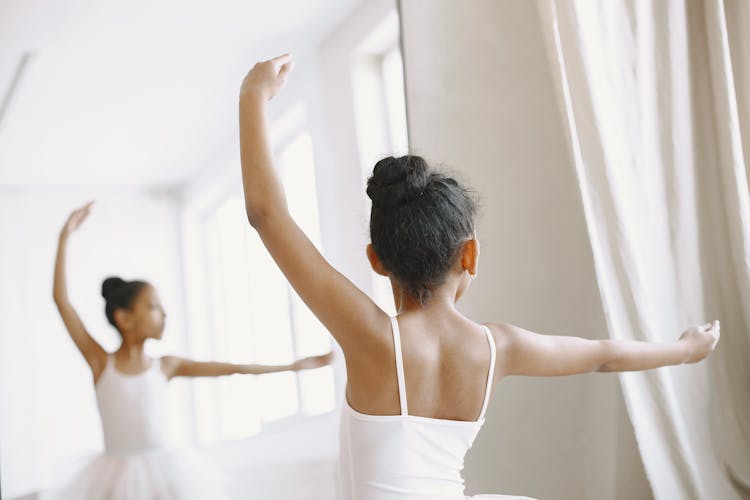 A Ballerina Practicing Ballet In Front Of The Mirror