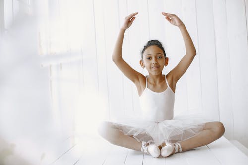 Little Ballerina Sitting with Her Arms Raised 