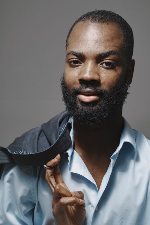 Free Close-up of a confident man with a beard in smart casual wear holding a jacket. Stock Photo