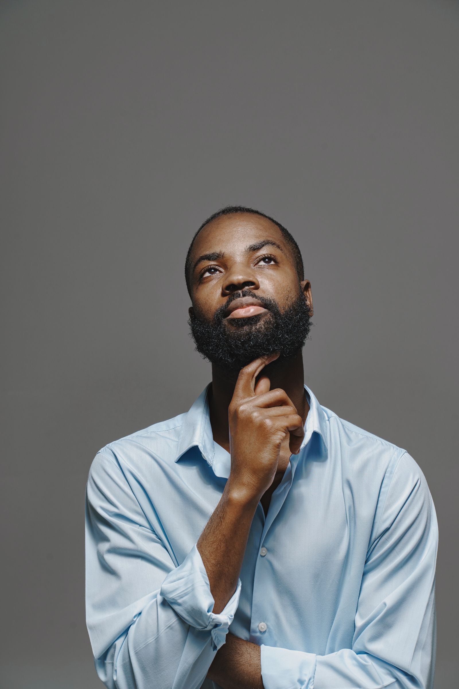 A Black man pauses in a thoughtful, composed moment. Erectile dysfunction is common, often tied to treatable conditions, and worth raising with a clinician.