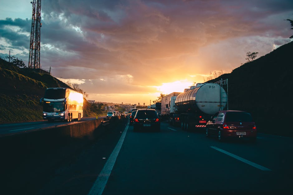 Traffic on a highway during a vivid sunset, capturing cars and trucks on the road.