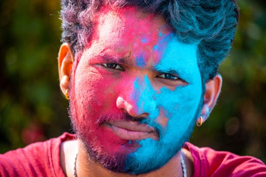 Vibrant portrait of a man with colorful Holi powder on his face celebrating the festival of colors.