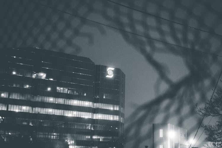 View Through Hole In Metal Fence On Modern Building In City