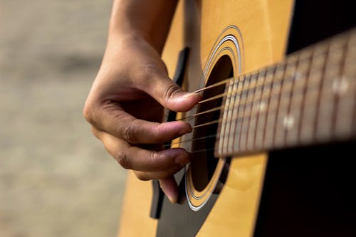 Close Up Shot of a Person Playing Guitar