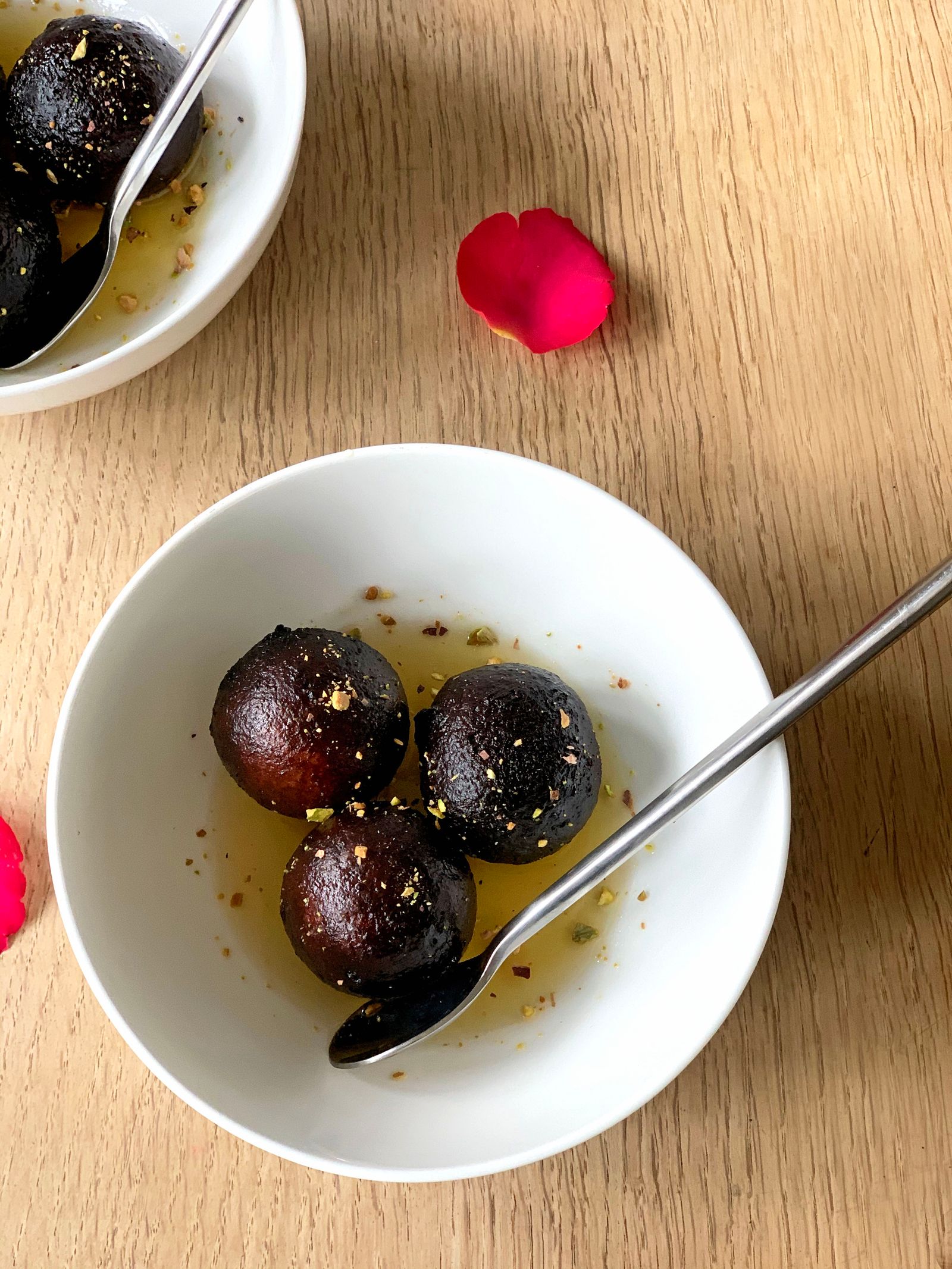 Gulab jamun served warm in a ceramic bowl