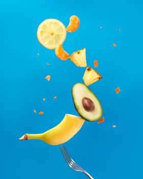 Vibrant photo of various fruits artistically floating against a bright blue backdrop.