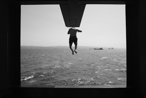 Black and White Photo of a Man Diving