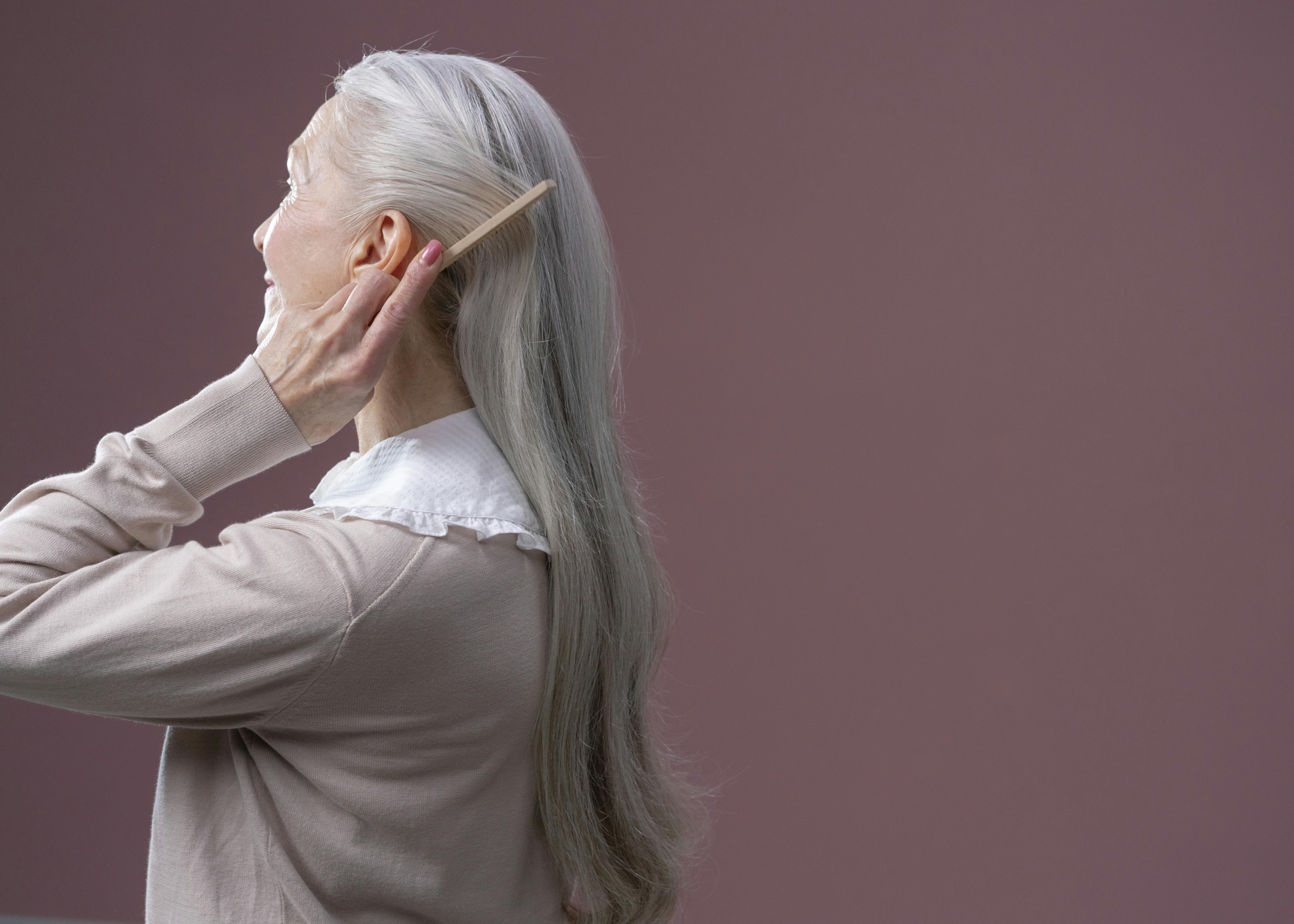 an elderly woman combing her hair