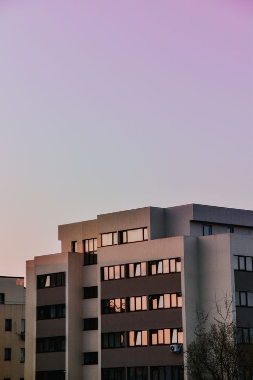 Free Contemporary apartment building facade at sunset, displaying modern architectural design. Stock Photo