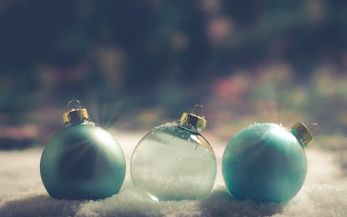 Two Green and Clear Baubles on snow