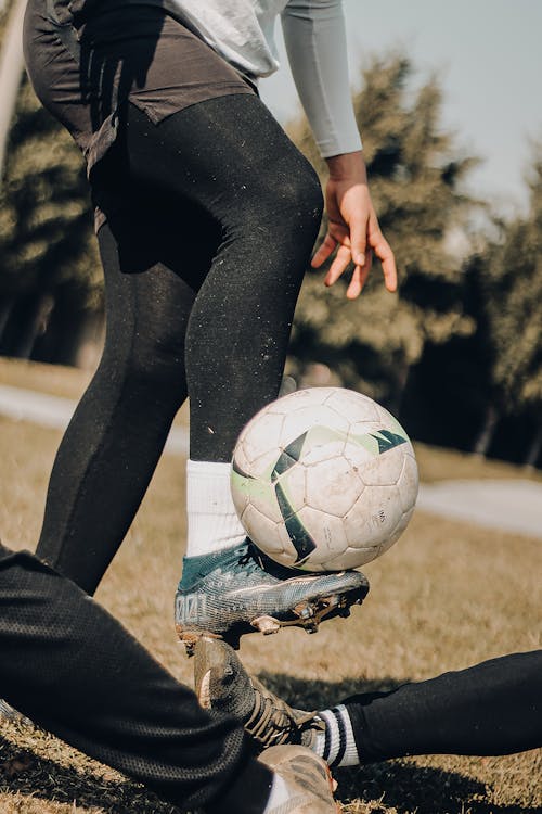 A Person Wearing Cleats while Playing Soccer Ball