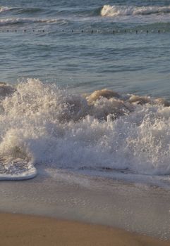 Capture of dynamic waves crashing onto a Turkish beach with clear blue sea.