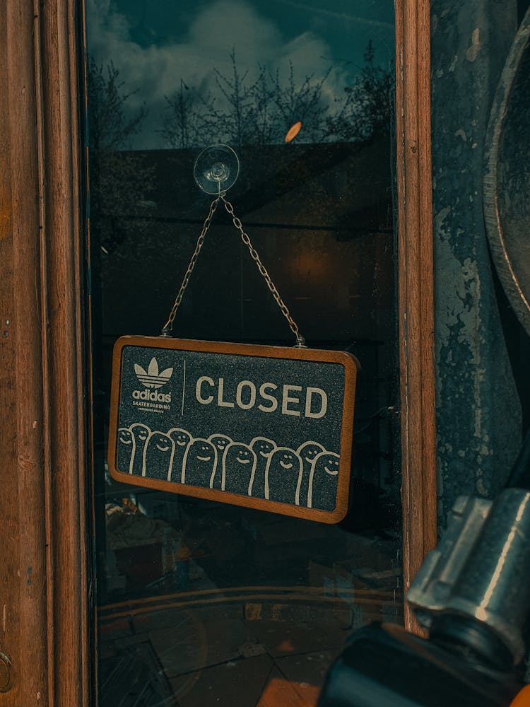 A Wooden Frame Signage Hanging On The Glass Door