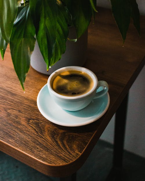 Cup of fresh black coffee served on wooden table