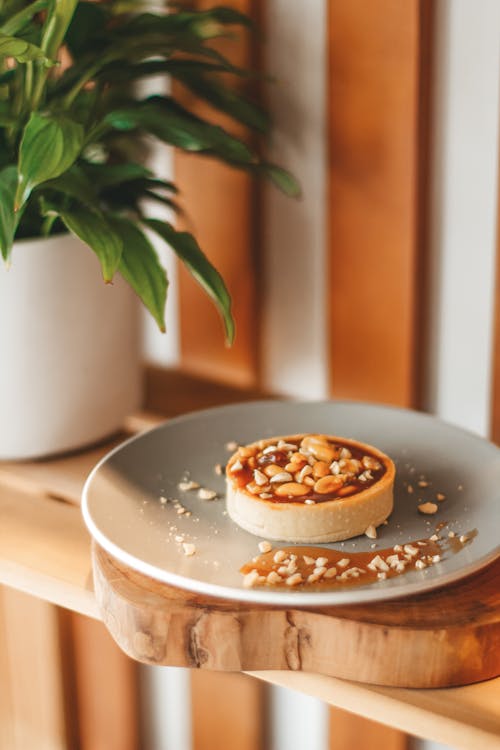 Delicious tart on plate served on wooden shelf