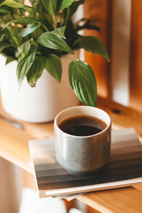 Cup of black coffee served on wooden shelf