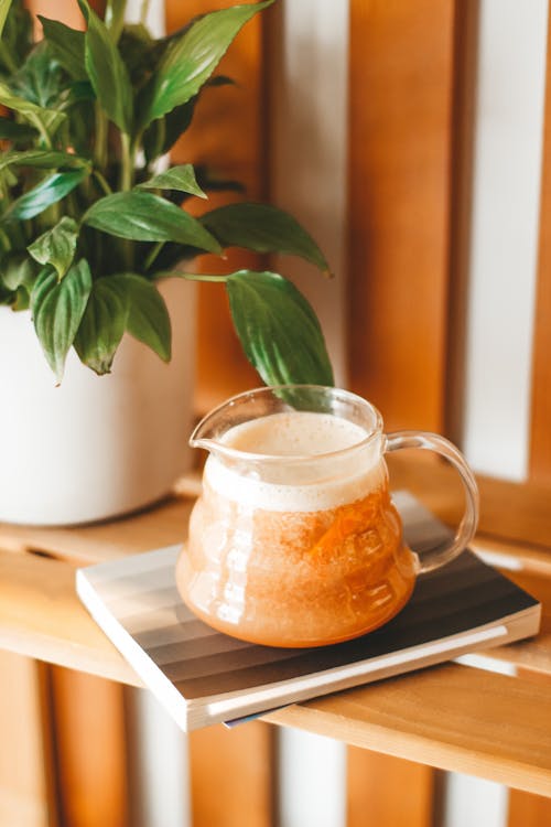 Fresh herbal tea in glass pot on shelf