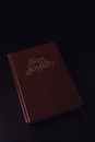 From above of red book with collection of songs placed on dark table