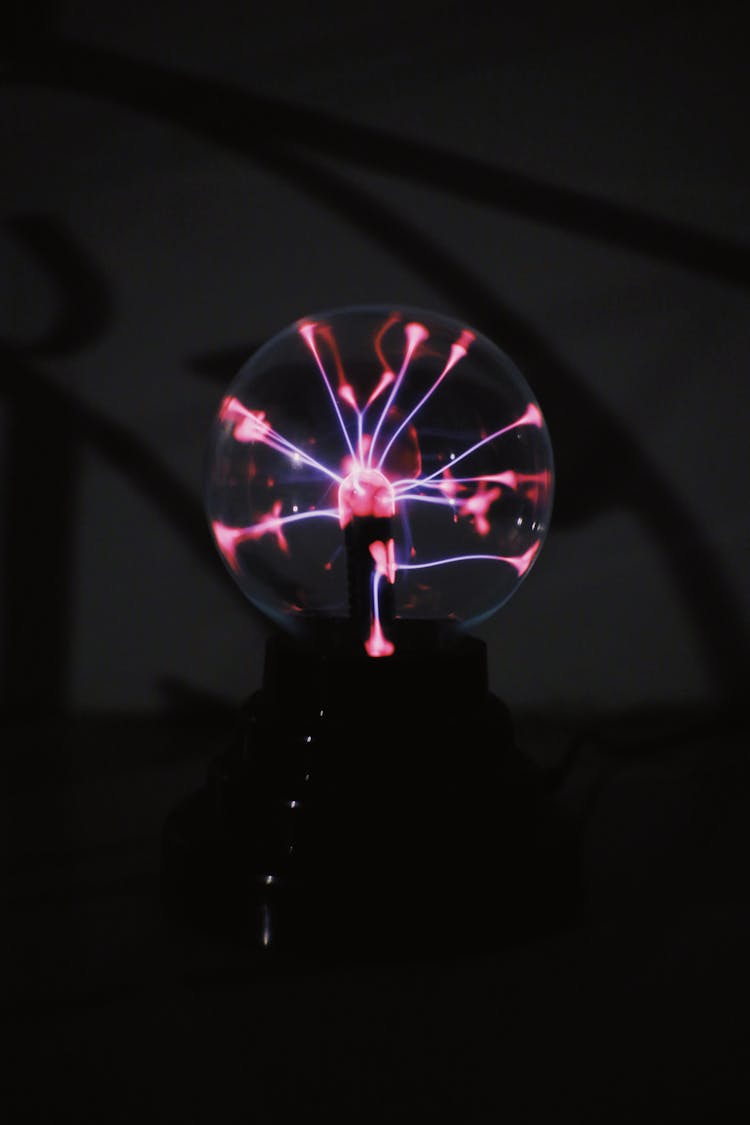 Shiny Plasma Ball With Neon Lights Against Dark Background