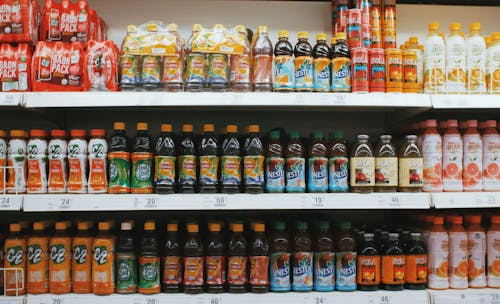 Shelves with various bottles of lemonades in supermarket