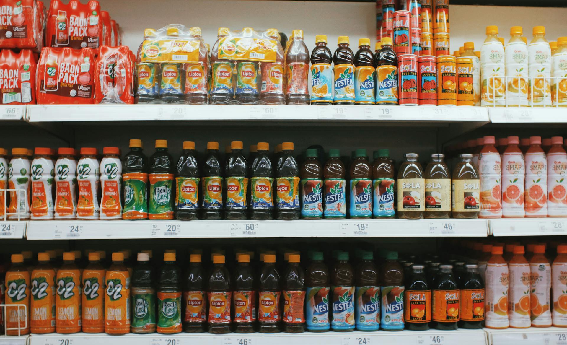 Shelves with various bottles of lemonades in supermarket