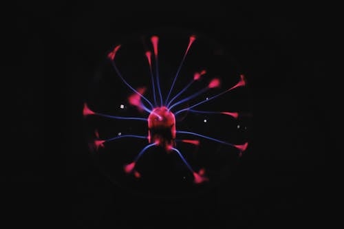 Bright glowing plasma ball with mystic colorful neon luminous placed in dark room