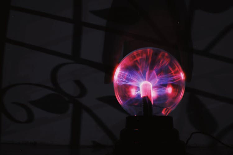 Glowing Plasma Ball With Red Light In Dark Room