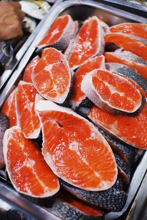 Free From above of fresh raw steaks of red salmon placed in heap in metal container in local market Stock Photo