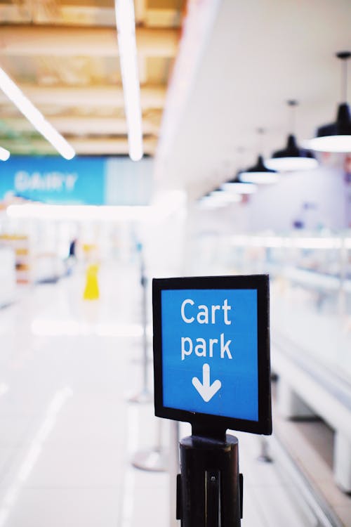 Signboard with Cart park inscription placed in hallway in modern supermarket against blurred background
